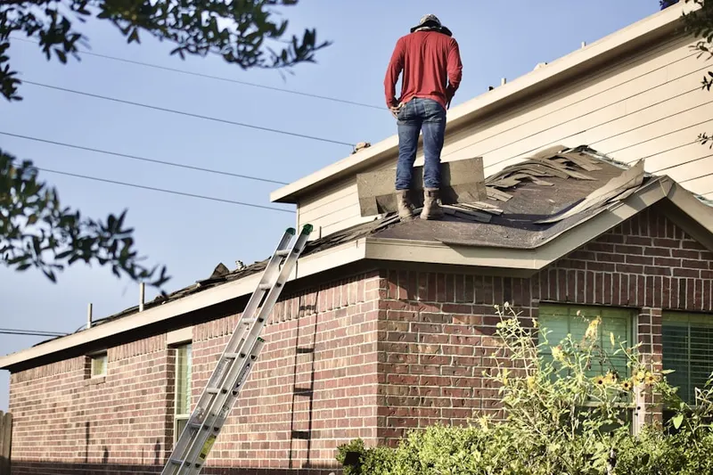 Professional roofer working on a residential roof in White Cottage